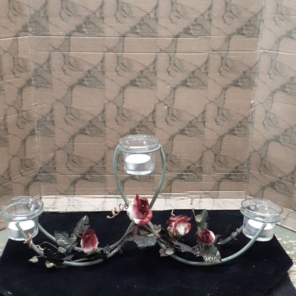 Long 3 candle black iron candle holder laced with trailing red roses.‎